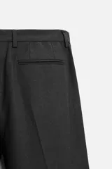 Pantalón de vestir slim fit color gris oscuro, confeccionado en tejido con viscosa. Cuenta con bolsillos frontales y traseros de vivo. Cierre frontal con cremallera y botón.