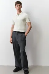 Remera polo de manga corta color crema, en tejido de punto acanalado de mezcla de algodón, con cuello clásico y medio cierre con cremallera.