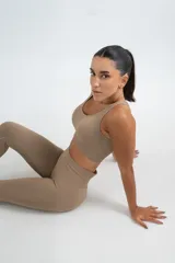 Top deportivo gris con breteles anchos y espalda deportiva.