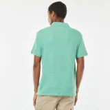 Remera verde de punto de piqué con cuello en V y mangas cortas.