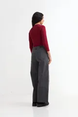 Pantalón de jean tiro alto, color gris oscuro lavado, de corte ancho y largo hasta el suelo.