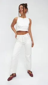 Pantalón de gabardina color blanco, de corte recto y tiro medio/alto, con bolsillos delanteros y traseros al estilo jean. Los pespuntes en contraste son de color rojo.