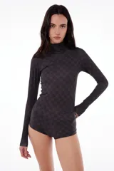 Polera negra de tela elastizada con estampado de monogramas a tono, cuello alto y mangas largas.