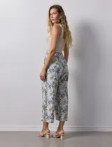 Pantalón crop de lino estampado con hojas en tonos verdes y azules. Tiene pretina trasera elastizada y bolsillos delanteros.