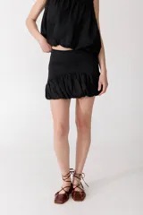 Minifalda negra de lino con cintura alta y ruedo con volados.