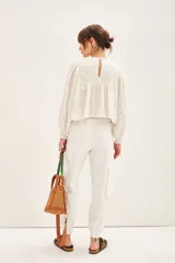 Pantalón cargo negro de corte holgado, con cierre y botones frontales, elástico en la cintura y en los ruedos. Cuenta con bolsillos laterales y en las piernas.