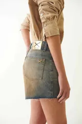 Short de jean con tiro bajo, efecto desgastado y estampado de serpiente. Tiene cuatro bolsillos, pasacintos, cremallera y botón metálico.