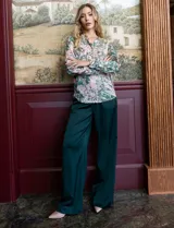 Pantalón palazzo de tiro alto color violeta, de satén. Tiene pretina delantera con pasadores, botón y cierre, pretina trasera elastizada y bolsillos verticales delanteros.