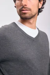 Sweater gris de tejido de punto con escote en V.