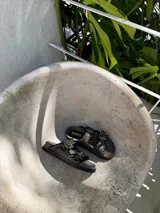 Sandalias de cuero color marrón con dos tiras anchas con hebillas metálicas y ojalillos.