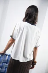 Remera azul marino de algodón con cuello redondo blanco y mangas cortas con bordado blanco.