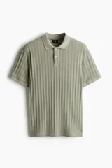 Remera polo verde salvia de punto texturizado, corte slim fit, manga corta, cuello clásico y tapeta con dos botones.