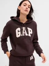 Buzo canguro marrón oscuro marca Gap, con capucha ajustable con cordón, bolsillo delantero y logo GAP estampado en blanco con borde rosa.