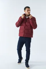 Campera inflada azul marino de nylon con cuello alto, cierre frontal con cremallera, bolsillos laterales con cierre y logo estampado en el pecho. El modelo usa talle M.