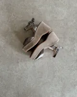 Sandalias de plataforma color gris topo, con capellada de cuero sintético, pulsera al tobillo con hebilla metálica y plataforma de 8 cm forrada en gamuza.