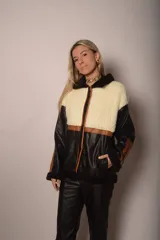 Campera de corderito negro y cuero sintético con detalles en tono café y cierre frontal.