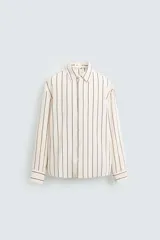 Camisa regular fit confeccionada en tejido con mezcla de modal, color blanco con rayas verticales negras. Cuello solapa, manga larga con puños abotonados y cierre frontal con botones.