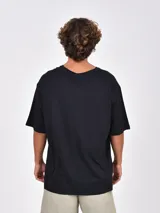 Remera negra de manga corta, con cuello redondo y calce amplio u oversize.