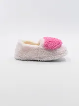 Pantuflas cerradas de tela peluda color rosa pastel, con interior beige y aplique de corazón celeste en el empeine.
