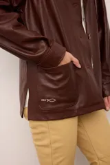 Chaquetón de cuero negro oversized, con corte recto y bolsillos delanteros. Presenta un bordado en los bolsillos inspirado en la costa atlántica.