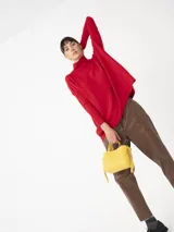 Sweater de color gris con diseño amplio y cuello alto, ideal para crear looks cómodos y elegantes.