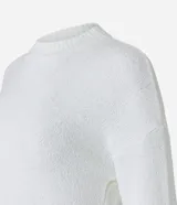 Suéter blanco de punto con textura mousse, cuello redondo y mangas largas.