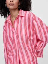 Camisa de popelina a rayas verticales rosas y blancas, de corte holgado y manga larga.