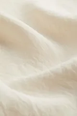 Falda larga color crema, con leve vuelo y tiro alto con elástico oculto en la cintura. Sin forrar.