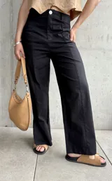 Pantalón negro de lino, de corte recto, con pinzas en la cintura y aberturas laterales en el ruedo.