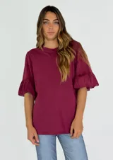 Remera color borgoña de corte holgado, con cuello redondo y mangas cortas con volados.