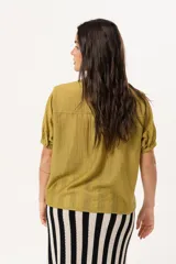 Blusa color verde oliva con cuello mao, mangas cortas abullonadas y cierre frontal con botones.