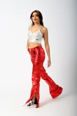 Pantalón largo de cuero sintético verde metalizado, de corte acampanado con aberturas laterales con botones a presión.