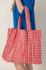 Bolso tipo tote con estampado a cuadros rojos y blancos, con doble asa de tela.