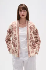 Chaqueta tipo kimono de tejido grueso color crema, con bordado floral en tonos rosados. Presenta un corte holgado y mangas anchas.