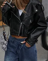 Campera negra de cuero sintético estilo biker con cierre cruzado, cuello con solapas y detalle de cordones con ojalillos metálicos en las mangas.