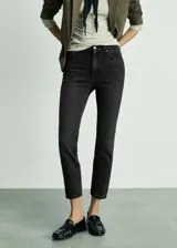Jeans negros de tiro medio, corte slim y largo cropped.
