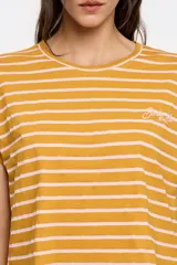 Remera de algodón color mostaza con rayas horizontales finas color rosa pálido. Tiene mangas cortas con dobladillo y un pequeño bordado en el pecho.