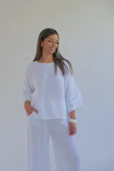 Blusa blanca de lino italiano con escote redondo y mangas 3/4 con volados.