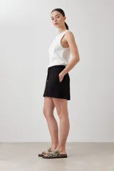 Short negro de corte recto con cintura elastizada y cordón ajustable. Presenta bolsillos laterales y detalle de costuras verticales en el frente.