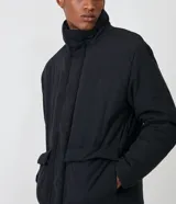 Campera puffer negra para hombre, con cuello alto, cierre frontal con botones a presión, bolsillos laterales y corte holgado. Fabricada en poliéster y poliamida.