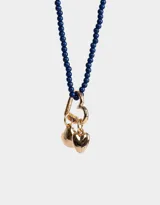 Collar corto de cuentas azul marino con dije de mosquetón dorado en forma de corazón y dijes colgantes de corazón dorado.