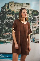 Vestido corto negro con patrón calado cuadrado, cuello redondo y mangas cortas con terminaciones a contratono en blanco.