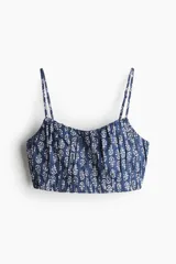 Top corto de breteles finos con estampado floral en tonos azules y blancos, escote corazón fruncido y elástico en la espalda y el bajo.