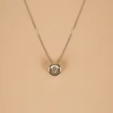 Conjunto de collar y dije con un brillante engarzado en oro blanco de 18k.