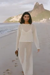 Top color crudo de tejido crochet calado, con cuello redondo y mangas largas.