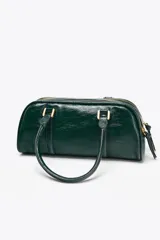 Bolso tipo bowling color verde oscuro charolado, con doble asa de mano y correa bandolera extraíble. Tiene doble compartimento con cierre de cremallera.