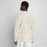 Camisa beige con rayas verticales finas, de corte clásico, manga larga y cuello camisero.