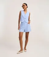 Short de vestir celeste de cintura alta, con cierre frontal y bolsillos laterales con tachuelas metalizadas.