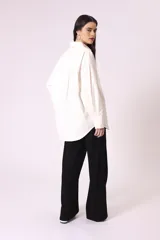 Camisa celeste de corte amplio, con cuello clásico, mangas largas y bolsillo en el pecho.