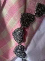 Cadena plateada para cintura con eslabones metálicos con forma de corazón con grabados.